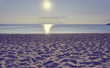 Sunny sea view with clouds and mountains in the bckground