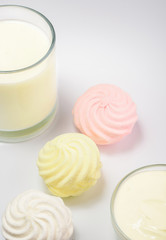 Glass of Milk and color marshmallows on a white background 