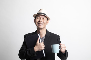Adult Asian man  with a book and cup of coffee.