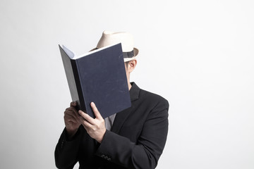 Adult Asian man  with a book cover her face.