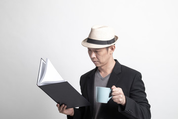 Adult Asian man  with a book and cup of coffee.