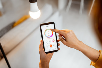Controlling light bulb temperature and intensity with a smartphone application. Concept of a smart...