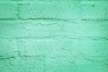 Closeup part of a brick wall covered with trendy turquoise or mint color plaster. Abstract modern texture background