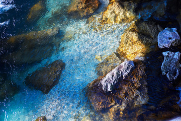 Turquoise crystal clear fresh water of the Alpine mountain river stream with rocky shore