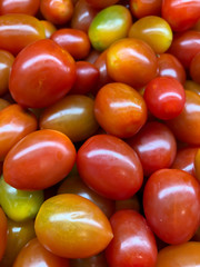 lots of tomatoes, cherry tomatoes on display in a supermarket