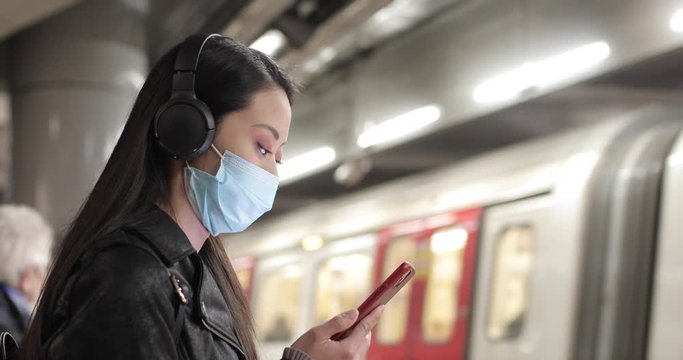 Chinese woman at train station in London wearing face mask