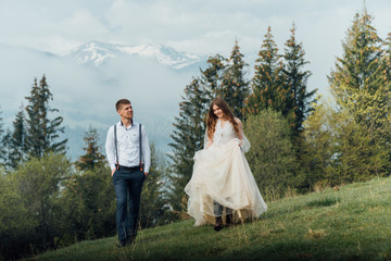 Beautiful young couple in the mountains. Wedding walk in the mountains.