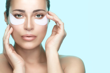 Beauty woman face with perfect clean skin using eye patches. Eye skin care concept. © Casther