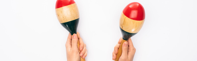 Cropped view of woman holding maracas on white background, panoramic shot