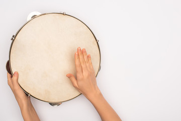 Cropped view of woman playing on tambourine on white background - obrazy, fototapety, plakaty