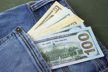 Banknotes of different denominations in the pocket of women's jeans, background. Concept, American...