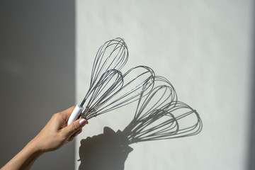 Hand holding group of balloon whisk mixing for kitchen cooking on white background
