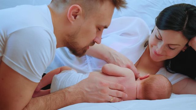 Breastfeeding baby. Happy young parents look at their newborn baby. Happy family