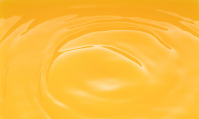 a swirling wave on the surface of orange juice.