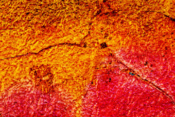 Surface texture with yellow orange and red color on a cracked surface structure. For abstract backgrounds.