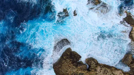 Fototapeten Wildes Ozeanwasser von oben - Wellen schlagen auf die Felsen - Luftaufnahmen © 4kclips