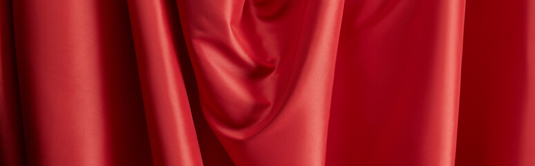 close up view of red soft and wavy silk textured cloth, panoramic shot