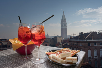 Cocktail, aperitif for two with the view of Venice in the background. Two glasses of spritz with...