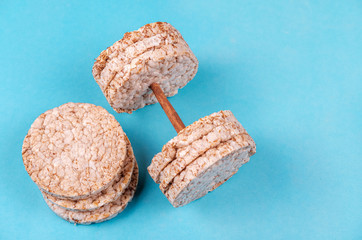 useful loaves of sprouted cereals in a round shape in the form of a dumbbell on a blue background. vegan breads for fitness. the concept of sport and nutrition