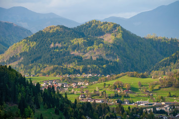 Fototapeta na wymiar Sunlit alpine valley, Hom mountain and slovenian village Podhom at sunny spring day