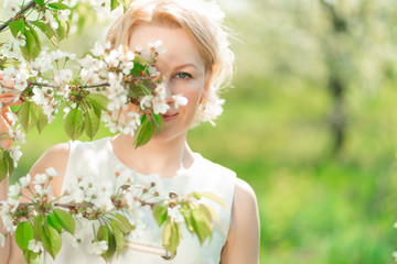 portrait blonde girl with branch of flowering tree