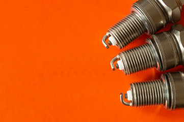 Car spark plug on orange background