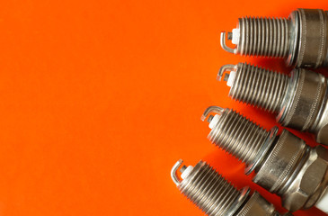 Car spark plug on orange background