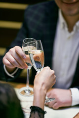 Beautiful young couple with glasses of Champaign in luxury restaurant. Couple have romantic evening in restaurant. 
