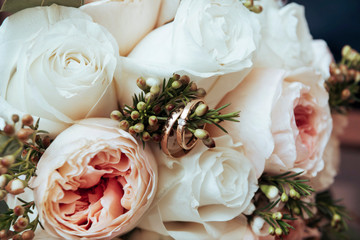 wedding rings on a flower bouquet of pink roses