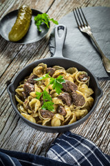 Italian pasta shells with beef sauce in cast iron pan.