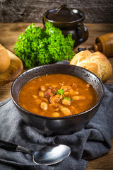 Beans with tomato sauce, bacon and sausage.