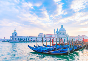 Fototapeta na wymiar Venetian gondolas on Grand Canal with Santa Maria della Salute Basilica in the background, Venice, Italy