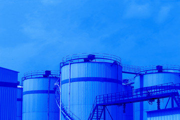 Oil storage tanks against a background of blue sky and white clouds