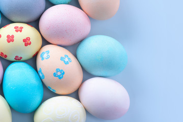 Fototapeta na wymiar Colorful Easter eggs dyed by colored water with beautiful pattern on a pale blue background, design concept of holiday activity, top view, copy space.
