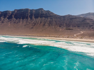 Aerial view of Famara beach with ocean and mountains in Lanzarote, Spain