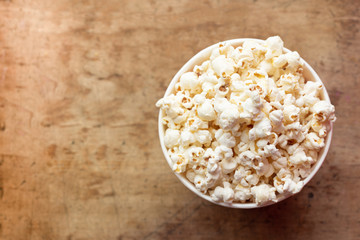popcorn in a bowl top view on a wooden background with place for text