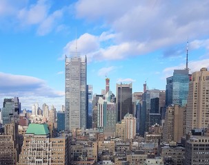 Fototapeta premium New York City cityscape with tall buildings, beautiful blue sky with clouds