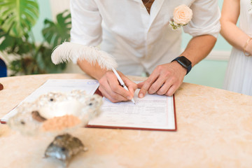 Obraz na płótnie Canvas groom signing wedding certificate