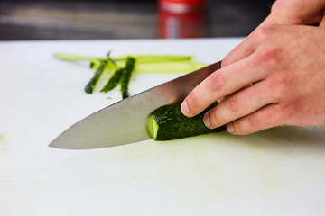 Hands peeling cut cucumber slices on a cutting board. Vegetables ready for salad. Tasty diet Vegetarian food
