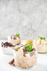 Set various fruit overnight oatmeal. Oats porridge with strawberry, bananas, chocolate, nuts in small portion jars. Summer breakfast oatmeal. Healthy vegan diet snack.