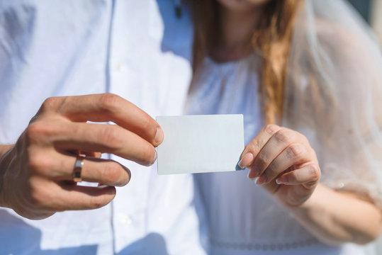 bride and groom holding card together