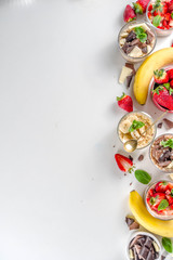 Set various fruit overnight oatmeal. Oats porridge with strawberry, bananas, chocolate, nuts in small portion jars. Summer breakfast oatmeal. Healthy vegan diet snack.