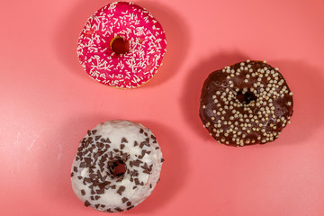 Tasty donuts on pink background. Top view