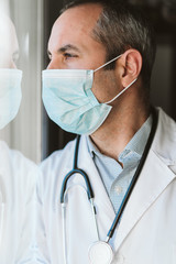 Fototapeta premium doctor man wearing protective mask and gloves indoors. Corona virus concept