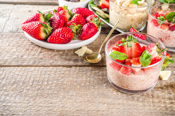 Set various fruit overnight oatmeal. Oats porridge with strawberry, bananas, chocolate, nuts in small portion jars. Summer breakfast oatmeal. Healthy vegan diet snack.