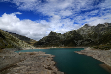 Fototapeta na wymiar Lago di Montespluga with village of Montespluga and Alps, Italy