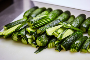 Sliced cucumbers on cutting board. Vegetables ready for salad. Tasty diet Vegetarian food
