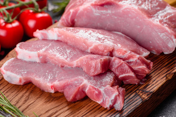 Fresh pieces pork ready to cook on a dark background in the kitchen