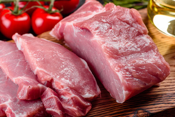 Fresh pieces pork ready to cook on a dark background in the kitchen