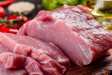 Fresh pieces pork ready to cook on a dark background in the kitchen